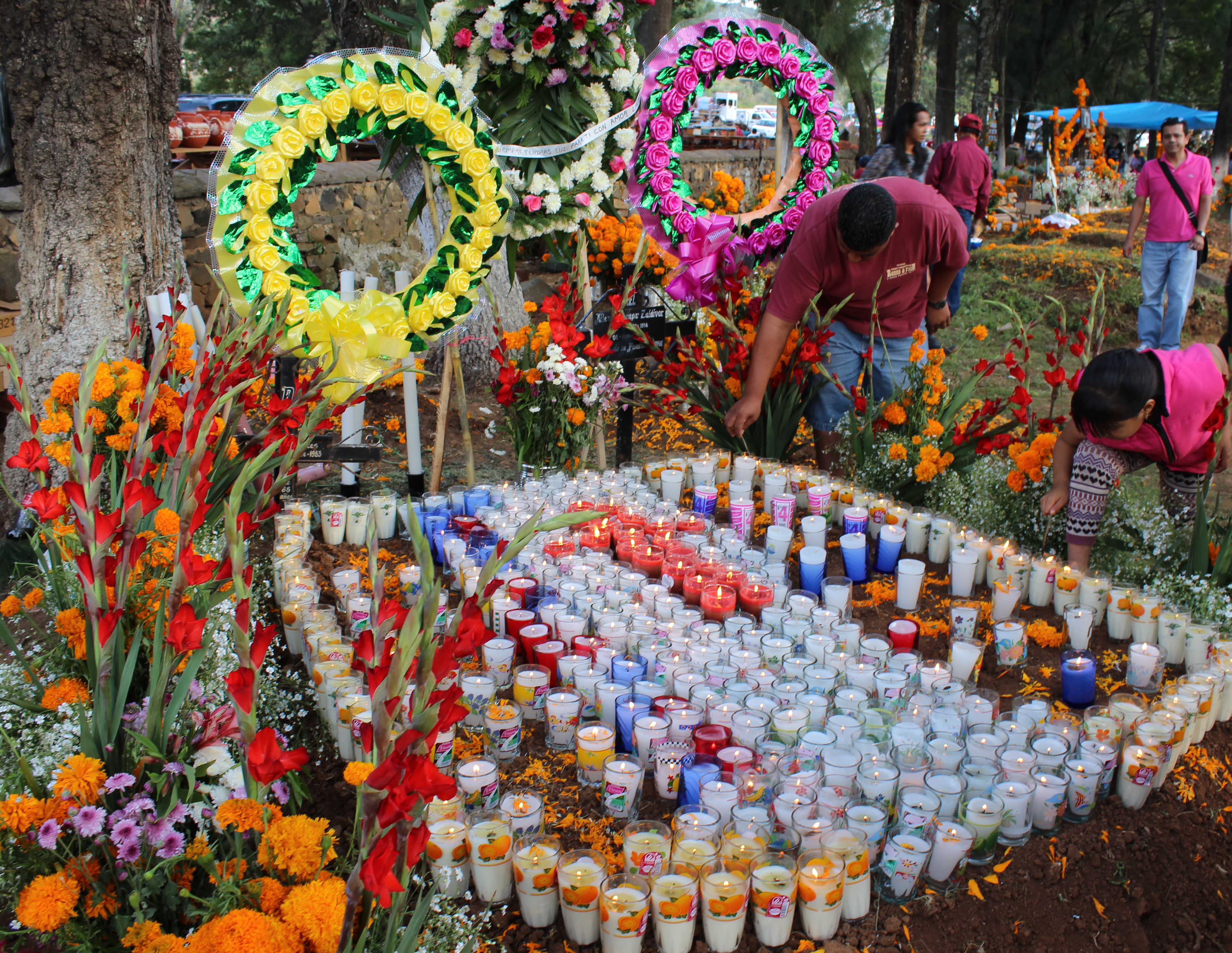 Family members light candles on an offering in Tzintzuntzán, Michoacán