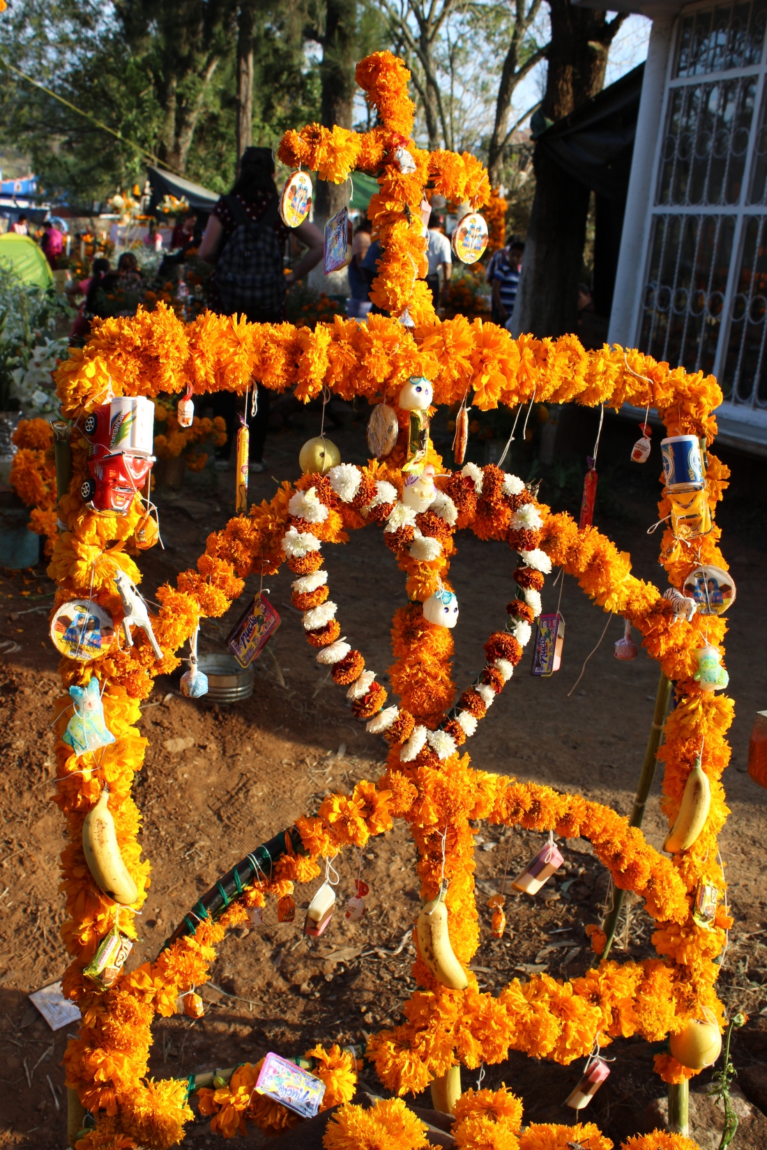 Offering built over a child's grave in Tzintzuntzan, Michoacán, decorated with marigold flowers, sugar skulls, fruit, toy cars and sweets